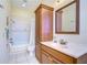 Bathroom features tub, integrated shower and tiled walls, sink and storage cabinet at 6801 Nowiki Ave, Hudson, FL 34667