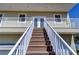 Stairway leads to the main door and balcony with white railings at 6801 Nowiki Ave, Hudson, FL 34667