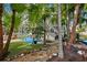 A charming backyard featuring a stone path, lush greenery, tropical trees, and a patio for outdoor entertaining at 7256 Westwind St, Weeki Wachee, FL 34607