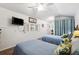 A bright bedroom with two beds, a ceiling fan, and a TV at 7256 Westwind St, Weeki Wachee, FL 34607