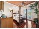 Inviting main bedroom featuring a four-poster bed, hardwood floors, and private balcony access at 7256 Westwind St, Weeki Wachee, FL 34607