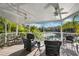 Inviting covered patio featuring ceiling fans and an outdoor dining area overlooking a serene waterfront view at 7256 Westwind St, Weeki Wachee, FL 34607