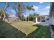 Spacious backyard featuring grass, a partial fence, mature trees, and a sunroom at 7431 Abington Ave, New Port Richey, FL 34655