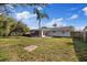 Expansive backyard featuring a screen-enclosed porch, mature trees, and a privacy fence at 7431 Abington Ave, New Port Richey, FL 34655