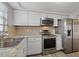 Well-lit kitchen features stainless steel appliances and stone-look countertops at 7431 Abington Ave, New Port Richey, FL 34655