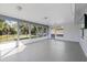 Light-filled sunroom with multiple windows, a ceiling fan, and access to the backyard at 7431 Abington Ave, New Port Richey, FL 34655