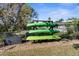 Storage rack for three kayaks, a black storage box, and a grassy backyard at 8225 Channel Dr, Port Richey, FL 34668