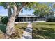 Home exterior featuring a screened in patio and a brick walkway leading to the house at 8225 Channel Dr, Port Richey, FL 34668