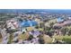 An aerial view of a community including a golf course, lake, and clubhouse at 9065 Mississippi Run, Weeki Wachee, FL 34613
