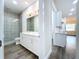 Bright bathroom with patterned tile shower, double vanity, and access to the kitchen at 9065 Mississippi Run, Weeki Wachee, FL 34613