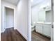 Hallway view into the bathroom, complete with sleek white toilet, vanity, and stylish flooring at 9065 Mississippi Run, Weeki Wachee, FL 34613