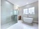 A modern bathroom with a glass shower, tub, and a large window at 9065 Mississippi Run, Weeki Wachee, FL 34613