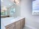 Bathroom vanity with double sinks, large mirror, and bright natural light at 9065 Mississippi Run, Weeki Wachee, FL 34613