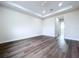 Expansive bedroom with a ceiling fan, tray ceiling, bright window, and sleek wood-look flooring at 9065 Mississippi Run, Weeki Wachee, FL 34613