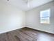 Bright bedroom features wood-look floors, white trim and a large window at 9065 Mississippi Run, Weeki Wachee, FL 34613