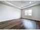 Large bedroom with a ceiling fan, tray ceiling, big window, and wood-look flooring at 9065 Mississippi Run, Weeki Wachee, FL 34613