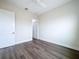 Bedroom featuring wood look floors, light walls, a ceiling fan and a white door and trim at 9065 Mississippi Run, Weeki Wachee, FL 34613