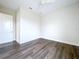 Bedroom features wood look floors, light walls, a ceiling fan and a white door at 9065 Mississippi Run, Weeki Wachee, FL 34613