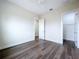Bright bedroom with wood-look floors and white trim, featuring an open door to the walk-in closet at 9065 Mississippi Run, Weeki Wachee, FL 34613