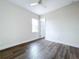 Bedroom featuring wood look floors, light walls, a ceiling fan and a window with views at 9065 Mississippi Run, Weeki Wachee, FL 34613