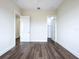 Bright bedroom with wood-look floors, white trim and doors to hall and walk-in closet at 9065 Mississippi Run, Weeki Wachee, FL 34613