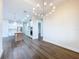 Dining room with chandelier, open to kitchen with wood floors and white walls at 9065 Mississippi Run, Weeki Wachee, FL 34613
