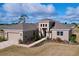 An exterior elevation of a beige one-story home with a brick walkway and a two-car garage at 9065 Mississippi Run, Weeki Wachee, FL 34613