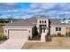 Beautiful single Gathering home featuring a three-car garage and well-manicured front lawn at 9065 Mississippi Run, Weeki Wachee, FL 34613