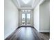A light-filled foyer features double glass doors and dark wood flooring, offering a bright and welcoming entrance at 9065 Mississippi Run, Weeki Wachee, FL 34613