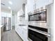 A well-appointed kitchen features stainless steel appliances, white cabinets and a white backsplash at 9065 Mississippi Run, Weeki Wachee, FL 34613