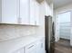 Contemporary kitchen with stainless steel refrigerator, white cabinets, and sleek countertops at 9065 Mississippi Run, Weeki Wachee, FL 34613