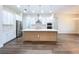 Open kitchen with large island, stainless steel appliances, and modern pendant lighting at 9065 Mississippi Run, Weeki Wachee, FL 34613