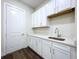 Bright laundry room featuring crisp white cabinetry with a quartz countertop and a sink at 9065 Mississippi Run, Weeki Wachee, FL 34613