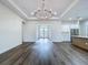 Bright living room featuring hardwood floors, modern chandelier, and access to the outdoor patio at 9065 Mississippi Run, Weeki Wachee, FL 34613