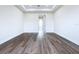 Spacious living room features a tray ceiling, wood floors, and an open doorway at 9065 Mississippi Run, Weeki Wachee, FL 34613