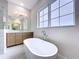 Luxurious bathroom showcasing a modern soaking tub, a vanity with a large mirror and sleek finishes at 9065 Mississippi Run, Weeki Wachee, FL 34613