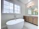Bright bathroom featuring a standalone tub, vanity with a large mirror, and modern lighting at 9065 Mississippi Run, Weeki Wachee, FL 34613