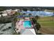 Aerial view of a community pool, tennis court, and lush landscaping at 9065 Mississippi Run, Weeki Wachee, FL 34613
