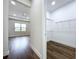 View into the walk-in closet with wire shelving and wood-look flooring, adjacent to the bedroom at 9065 Mississippi Run, Weeki Wachee, FL 34613