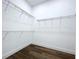 Spacious walk-in closet with wire shelving and wood-look flooring at 9065 Mississippi Run, Weeki Wachee, FL 34613