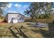 Backyard showcasing a wooden fence, seating area with a fire pit, and the rear exterior of the home at 9250 Peony St, New Port Richey, FL 34654