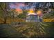 Backyard view at sunset features a wooden fence, seating around a fire pit, and the house at 9250 Peony St, New Port Richey, FL 34654