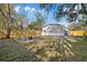 View of the backyard with wooden privacy fence, fire pit, and the rear of the house at 9250 Peony St, New Port Richey, FL 34654