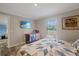 Bedroom features a decorative quilt, television, and a large window at 9250 Peony St, New Port Richey, FL 34654