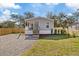 Charming home featuring a cozy front porch, gravel driveway and a newly installed wooden fence at 9250 Peony St, New Port Richey, FL 34654