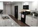 Well-lit kitchen with white cabinetry, black appliances, and durable granite countertops at 6030 Redwood Dr, New Port Richey, FL 34653