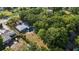 Aerial view of the home with a pool, patio, lush greenery, and spacious backyard surrounded by mature trees at 1101 N Betty Ln, Clearwater, FL 33755