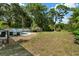 Expansive backyard featuring a pool, lounge chairs, and a charming storage shed surrounded by lush greenery at 1101 N Betty Ln, Clearwater, FL 33755