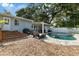Backyard featuring a pool, chairs, steps, and a grill at 1101 N Betty Ln, Clearwater, FL 33755