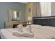 Elegant bedroom with a vanity, large mirror, lamps and folded towels on the bed at 1101 N Betty Ln, Clearwater, FL 33755